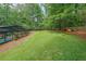 Lush green backyard with a screened-in pool and ample space for outdoor activities and relaxation at 9805 Buice Rd, Alpharetta, GA 30022