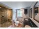 Bathroom featuring double sinks, a toilet, and a shower with stone walls and floor at 9805 Buice Rd, Alpharetta, GA 30022