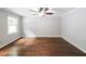 This light filled bedroom with hardwood floors offers ample space, a ceiling fan and a large window at 9805 Buice Rd, Alpharetta, GA 30022