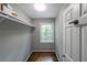 Walk-in closet with built-in shelving, a window, hardwood flooring, and white trim at 9805 Buice Rd, Alpharetta, GA 30022