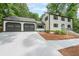 Traditional two-story home with a two-car garage and well-manicured lawn and shrubs at 9805 Buice Rd, Alpharetta, GA 30022