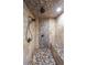 Shower stall showcasing stone walls and floor with both overhead and handheld shower heads at 9805 Buice Rd, Alpharetta, GA 30022