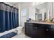 Bathroom with dark cabinets, granite countertop, mirror, toilet, shower with blue curtain at 2520 Carmel Way, Alpharetta, GA 30009