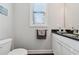 Neutral powder room with a white vanity, dark countertop and a framed window at 2520 Carmel Way, Alpharetta, GA 30009