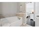 Bright bathtub with tiled surround offers a relaxing retreat next to Primary bedroom at 2520 Carmel Way, Alpharetta, GA 30009