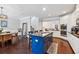 Open kitchen and dining area with a navy blue kitchen island, modern lighting, and hardwood floors at 2520 Carmel Way, Alpharetta, GA 30009