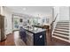 Open concept kitchen with island, stainless steel dishwasher and adjacent dining area and staircase at 2520 Carmel Way, Alpharetta, GA 30009