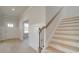 Hallway featuring staircase, wainscoting and view of the home's front door, windows and door at 117 Compass Rd, Hampton, GA 30228