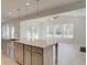 Kitchen island with stainless steel sink overlooking a living area with lots of windows at 117 Compass Rd, Hampton, GA 30228