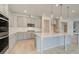 Spacious kitchen with an island and modern stainless steel appliances and gray cabinetry at 117 Compass Rd, Hampton, GA 30228