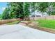 Large backyard featuring a play structure, retaining walls, and lush landscaping at 2115 Bentbrooke Trl, Lawrenceville, GA 30043