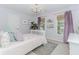 This cozy bedroom is decorated with modern light fixture, purple curtains and multiple windows at 2115 Bentbrooke Trl, Lawrenceville, GA 30043