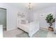 This bedroom has neutral decor, a modern light fixture, and an ornamental plant in the corner at 2115 Bentbrooke Trl, Lawrenceville, GA 30043