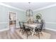 Bright dining room adjacent to the kitchen, featuring a modern light fixture and hardwood floors at 2115 Bentbrooke Trl, Lawrenceville, GA 30043