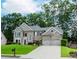 Elegant two-story home boasts a manicured lawn, brick facade, and a three-car garage at 2115 Bentbrooke Trl, Lawrenceville, GA 30043