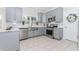 Well-lit kitchen featuring sleek stainless steel appliances, grey cabinets, and stone countertops at 2115 Bentbrooke Trl, Lawrenceville, GA 30043
