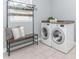 Convenient laundry room featuring washer, dryer, bench, and overhead storage at 2115 Bentbrooke Trl, Lawrenceville, GA 30043