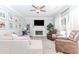 Bright living room with a fireplace, sofa, and two leather chairs, illuminated by natural light from large windows at 2115 Bentbrooke Trl, Lawrenceville, GA 30043