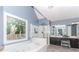 This bright main bathroom has a large tub, glass shower, and double sink vanity at 2115 Bentbrooke Trl, Lawrenceville, GA 30043