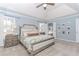 This main bedroom boasts a large bed, blue walls, and natural light from the window at 2115 Bentbrooke Trl, Lawrenceville, GA 30043