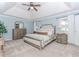 This spacious main bedroom features blue walls, a ceiling fan, and a large bed with floral bedding at 2115 Bentbrooke Trl, Lawrenceville, GA 30043