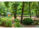 Community playground featuring slides and swings, surrounded by mature trees and landscaping at 2115 Bentbrooke Trl, Lawrenceville, GA 30043
