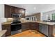 Well-lit kitchen with dark wood cabinetry, stainless steel appliances, and granite countertops at 3737 Falls Trl, Winston, GA 30187