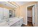 Bathroom with dual sinks, white cabinets, and a large mirror over the vanity at 7198 Golfside Se Dr, Covington, GA 30014