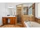 Bathroom featuring a soaking tub, glass-enclosed shower, tile floors, and vanity area at 7198 Golfside Se Dr, Covington, GA 30014