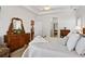 Bedroom with plush carpet and traditional dresser leads to a bathroom with a soaking tub at 7198 Golfside Se Dr, Covington, GA 30014