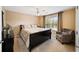 Cozy bedroom with a ceiling fan, neutral walls, and large window providing natural light at 7198 Golfside Se Dr, Covington, GA 30014