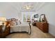 Spacious bedroom features a decorative tray ceiling, chair, and traditional wood furniture at 7198 Golfside Se Dr, Covington, GA 30014