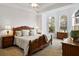 Bedroom with traditional wood furniture, tray ceiling, carpet floors, and natural light at 7198 Golfside Se Dr, Covington, GA 30014