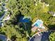 Aerial view of a community pool, tennis courts and a parking lot surrounded by trees and beautiful landscaping at 7198 Golfside Se Dr, Covington, GA 30014