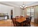 Formal dining room with wood table, seating for six, and large windows at 7198 Golfside Se Dr, Covington, GA 30014