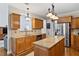Open concept kitchen with stainless steel refrigerator, granite island, and pendant lighting at 7198 Golfside Se Dr, Covington, GA 30014