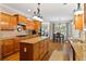 Open kitchen layout featuring granite counters, stainless appliances, and hardwood floors at 7198 Golfside Se Dr, Covington, GA 30014