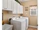 Functional laundry room with white cabinets, a sink, and a window for natural light at 7198 Golfside Se Dr, Covington, GA 30014