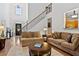 Bright living room with hardwood floors, high ceilings, and a staircase at 7198 Golfside Se Dr, Covington, GA 30014