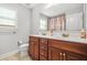 Double sink bathroom with wooden vanity, large mirror, and modern fixtures at 2241 Chaseford Ln, Powder Springs, GA 30127
