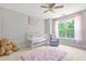 The bedroom displays a crib, rocking chair, plush rug and a large sunlit window at 2241 Chaseford Ln, Powder Springs, GA 30127