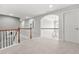 Open hallway with carpet and white bannister leading to rooms with arched entries at 2241 Chaseford Ln, Powder Springs, GA 30127