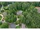Aerial view of home on wooded lot, long driveway, mature trees, lush landscaping and neighborhood at 140 Silvermere, Fayetteville, GA 30215