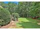 Lush green backyard with a stone pathway leading to a well-maintained lawn and privacy-ensuring foliage at 140 Silvermere, Fayetteville, GA 30215