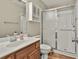Neat bathroom featuring a single vanity, toilet, and shower with a sliding glass door and modern fixtures at 140 Silvermere, Fayetteville, GA 30215