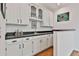 Charming butler's pantry with white cabinetry, black countertops, and hardwood floors at 140 Silvermere, Fayetteville, GA 30215