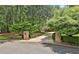 Charming driveway entrance with brick pillars and lush greenery leading to the inviting home beyond at 140 Silvermere, Fayetteville, GA 30215