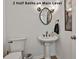 Neat half bath with pedestal sink, decorative mirror and lighting, and modern fixtures at 140 Silvermere, Fayetteville, GA 30215