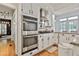 Bright kitchen featuring stainless steel appliances, including double ovens, and white cabinets at 140 Silvermere, Fayetteville, GA 30215