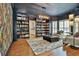Cozy living room features beautiful built-in bookshelves, hardwood floors, overhead light, and floral wallpaper at 140 Silvermere, Fayetteville, GA 30215